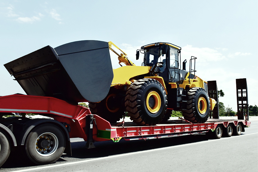 oil & gas heavy equipment being transported on a flatbed