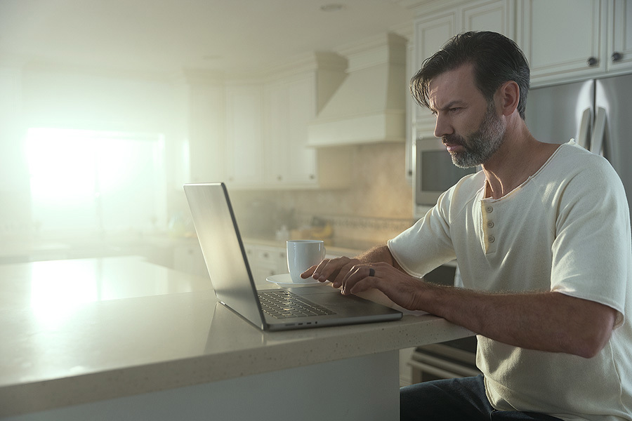 person sitting at a kitchen isle with a laptop