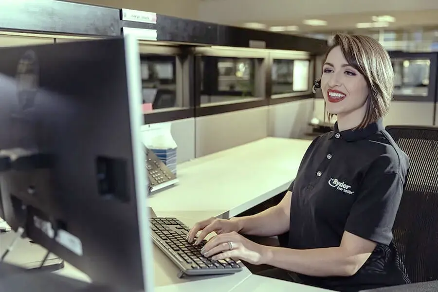 Ryder transportation management specialist smiling as she works on computer